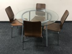 A circular glass topped dining table on metal base,
