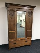 An Edwardian oak mirror door wardrobe