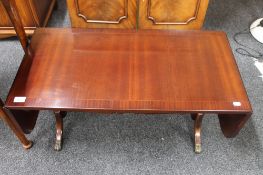 An inlaid mahogany Strongbow drop leaf coffee table on brass feet