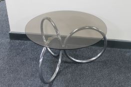 A circular smoked glass topped coffee table on a chrome base