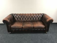 A brown button leather Chesterfield three seater bed settee