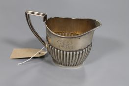 A silver milk jug, Walker and Hall, Chester 1906, 200.3g.