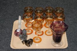 A tray containing a set of nine amber glass wine glasses,