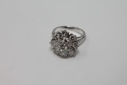 A white gold three tier diamond cluster ring, size O, approximately 2.5ct.