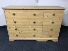 An eight drawer pine effect chest and a pine 4'6 headboard