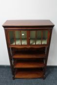 A set of Victorian inlaid mahogany open bookshelves with cupboard above