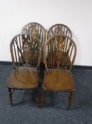A set of four oak wheel back dining chairs