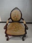 A late 19th century heavily carved salon armchair