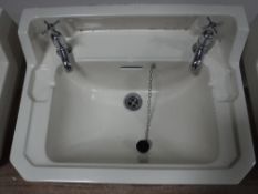 Three cream ceramic wall sinks,