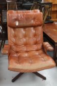 A Swedish Mobel tan button leather swivel armchair