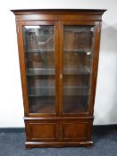 A reproduction mahogany double door display cabinet retailed by Collard & Collard
