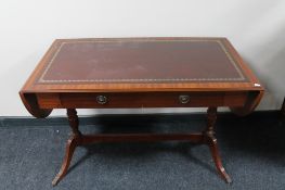 A reproduction mahogany leather topped sofa table with under stretcher