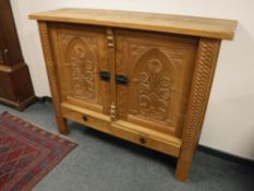 A carved oak double door side cabinet,