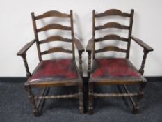 A pair of oak ladder back carver armchairs