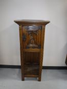 An early 20th century carved oak cabinet on stand