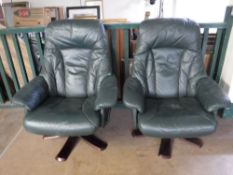 A pair of green leather swivel armchairs