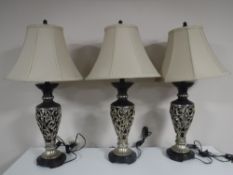 A set of three contemporary table lamps with shades