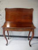 An antique mahogany foldover tea table