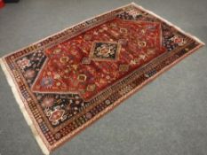 A Kashgai rug, the central medallion on red ground surrounded by flowerhead borders,