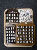 Three wooden thimble stands and a large collection of china thimbles