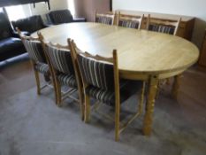 A circular blonde oak extending dining table with two leaves and six chairs