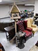 A cast metal bird bath and wooden bird house