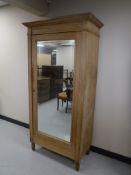 An early 20th century pine mirror door wardrobe