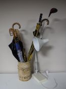 A pottery stick stand containing part companion set, walking sticks umbrellas,