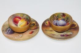 A Royal Worcester cup and saucer, hand painted with panels of fruit, signed Ricketts,