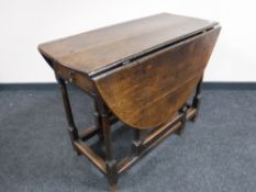 An antique oak gate leg table fitted a drawer