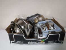 A box containing three trays of cutlery, stainless steel lidded entree dishes, assorted glassware,