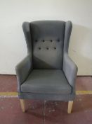 A twentieth century wing back armchair upholstered in a blue button fabric