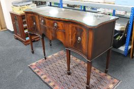 A inlaid mahogany serpentine fronted sideboard with lion mask handles