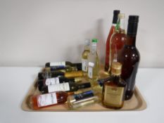 A tray of various alcohols including Napoleon Brandy, Harvey's Sherry, Merlot,