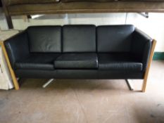 A beech framed black leather three seater settee