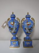 A pair of Noritake twin handled gilded vases with lids on stands,