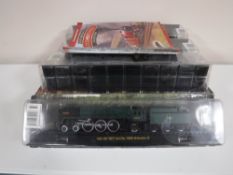 Seven model trains on stands in packaging, two include Evening star, Winston Churchill,