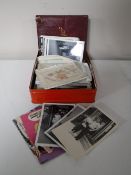 A tin of monochrome photos, vintage postcards,