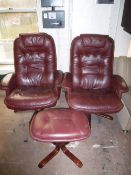 A pair of burgundy leather swivel armchairs,