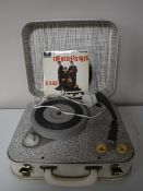 A mid 20th century Pye Golden Guinea table top record player together with four 45's including The