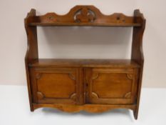 An antique mahogany wall cabinet with fitted shelf above