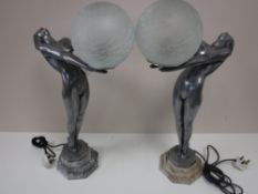 A pair of Art Deco style figural table lamps with glass ball shades on marble bases