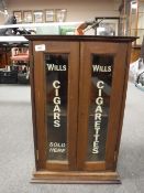 A mahogany double door cabinet with Wills Cigars advertisement
