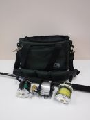 A camera bag containing an Abu Garcia Ambassador multiplying reel, a Pendelmar multiplying reel,