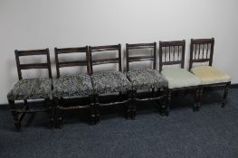 A set of four oak dining chairs upholstered in a tapestry fabric,