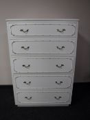 A white and gilt five drawer chest