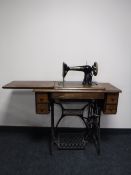 A Singer treadle sewing machine in an oak table