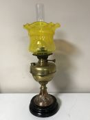 An early twentieth century brass National Lamp oil lamp with yellow glass shade and chimney