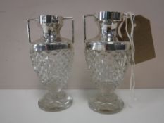A pair of sterling silver topped, cut glass vases,