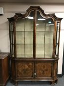 A Georgian style mahogany display cabinet with arched top above double cupboards below,